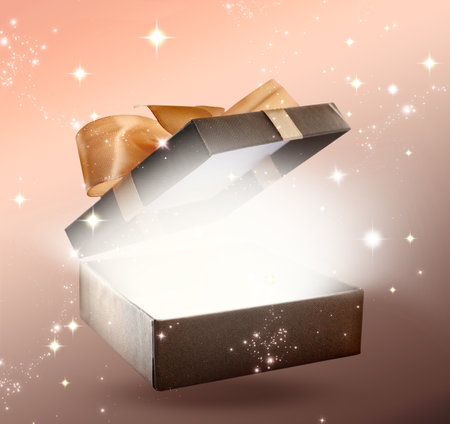 Beautiful gift box with magic light on color background