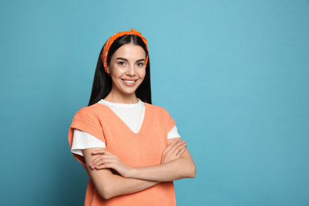 Young woman wearing stylish bandana on light blue background, space for textの写真素材