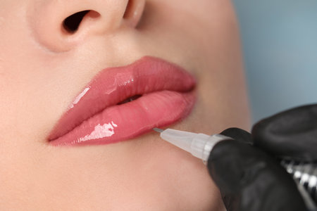 Young woman during procedure of permanent lip makeup in beauty salon, closeupの写真素材
