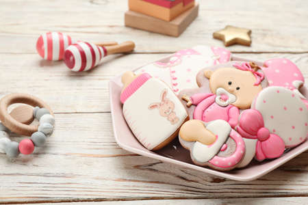 Plate of baby shower cookies and accessories on white wooden tableの写真素材