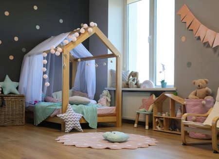 Stylish child room interior with house bed and different toysの写真素材
