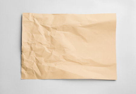 Sheet of crumpled brown paper on white background, top viewの写真素材
