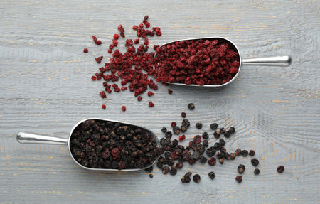 Dried red and black currants on gray wooden table, flat lay