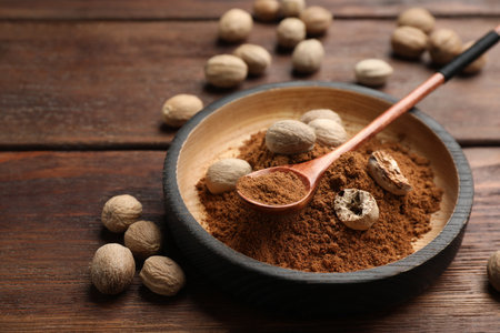 Nutmeg powder and seeds on wooden tableの写真素材