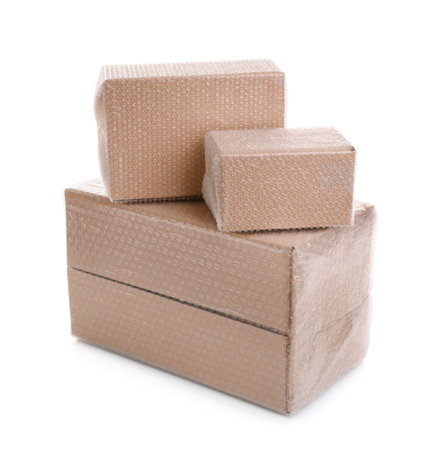 Cardboard boxes packed in bubble wrap on white backgroundの写真素材