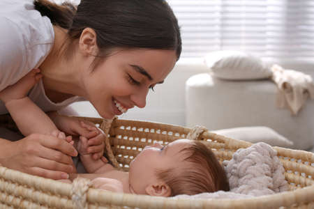 Young woman with her little baby in room at home