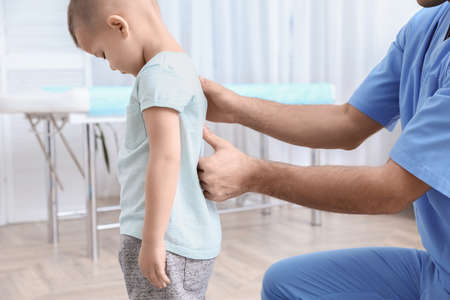 Orthopedist examining child's back in clinic, closeup. scoliosis treatmentの写真素材