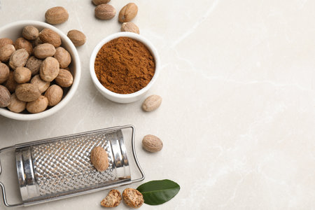 Nutmeg powder and seeds on white table, flat lay. Space for textの写真素材
