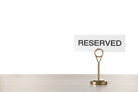Elegant sign Reserved on wooden table against white background, space for textの写真素材
