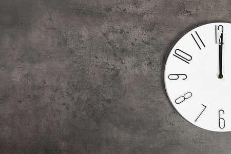 Stylish analog clock hanging on gray wall, space for textの写真素材