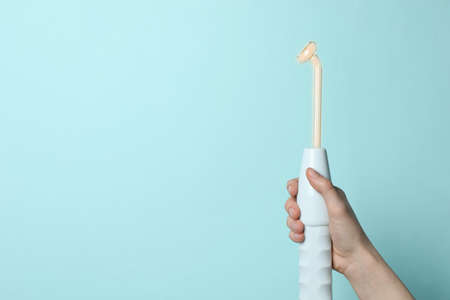 Woman with darsonval on turquoise background, closeup. Space for textの写真素材