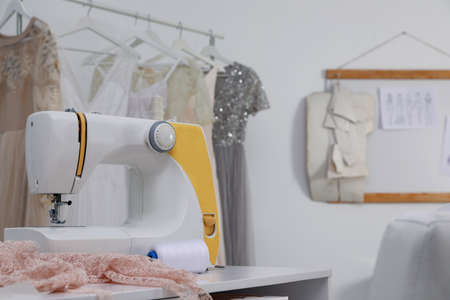 Sewing machine and fabric on table in dressmaking workshop