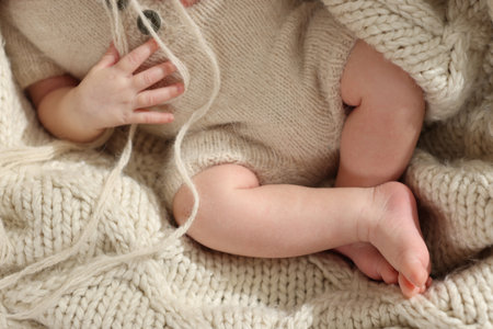 Top view of adorable newborn baby on knitted plaid, closeupの写真素材