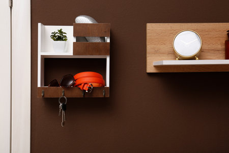 Stylish hanger for keys on brown wall in hallwayの写真素材
