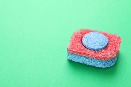 Dishwasher detergent tablet on green background, closeup. Space for textの写真素材