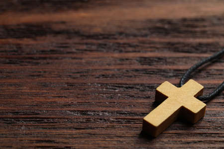 Wooden Christian cross on table, closeup. Space for textの写真素材
