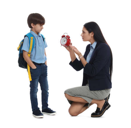 Teacher with alarm clock scolding pupil for being late against white background