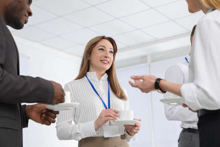 Group of people chatting during coffee break indoors
