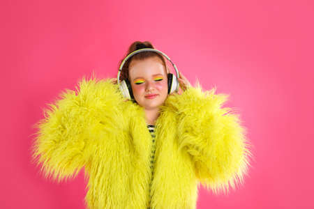 Cute indie girl with headphones on pink backgroundの写真素材