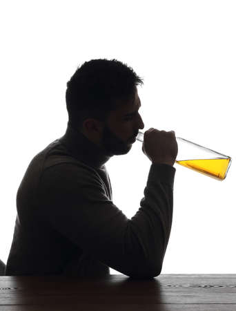 Silhouette of addicted man drinking alcohol on white backgroundの写真素材