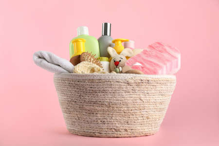 Basket with baby cosmetics and accessories on pink backgroundの写真素材