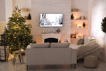 Cozy living room interior with beautiful Christmas tree and fireplaceの写真素材