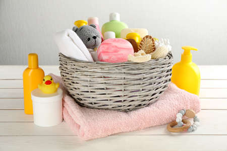 Wicker basket with baby cosmetics and accessories on white wooden tableの写真素材