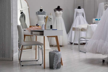Dressmaking workshop interior with wedding dresses and equipmentの写真素材