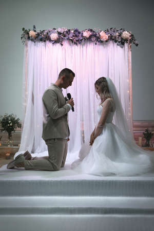 Groom saying marriage vow at wedding ceremonyの写真素材