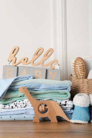 Baby clothes, toy and accessories on wooden tableの写真素材