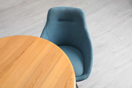 Stylish comfortable chair near wooden table in room, above view