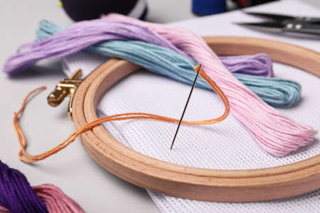 Set of embroidery equipment on light gray background, closeup