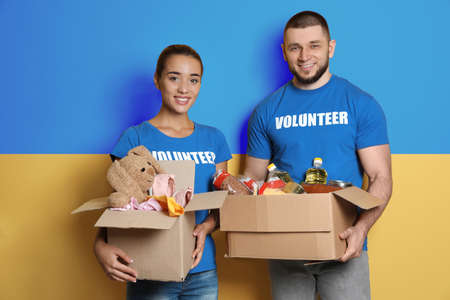 Volunteers holding donation boxes with Ukrainian flag on background. Help during warの写真素材