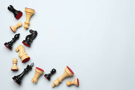 Many different chess pieces on white background, flat lay. Space for textの写真素材