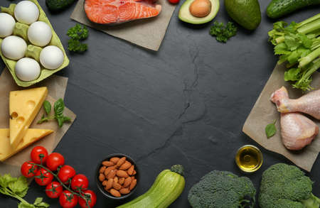 Frame of keto diet products on black table, space for text