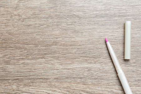 Lip pencil on wooden table, flat lay with space for text. cosmetic product