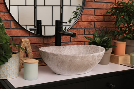 Stylish sink and beautiful green houseplants in the bathroom. interior design