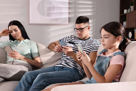 internet addiction. Family with different gadgets on sofa at home