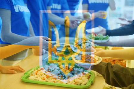 Double exposure of volunteers serving food to refugees and Ukrainian flag, closeup. Help during warの写真素材