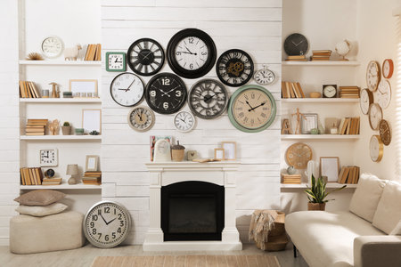 Stylish room interior with comfortable sofa, fireplace and collection of wall clocksの写真素材