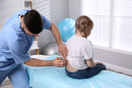 Orthopedist examining child's back in clinic. scoliosis treatmentの写真素材