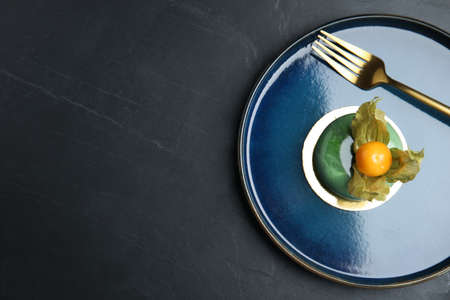 Delicious dessert decorated with physalis fruit on black table, top view. Space for textの写真素材