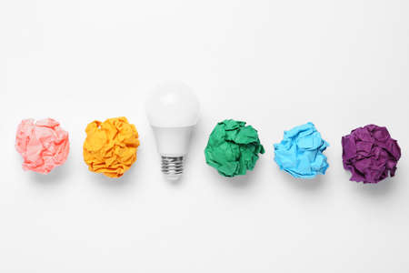 Creative flat lay composition with lightbulb and colorful paper balls on white background. idea...