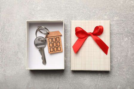 Key with trinket in gift box on light gray stone background, flat lay. house warming partyの写真素材