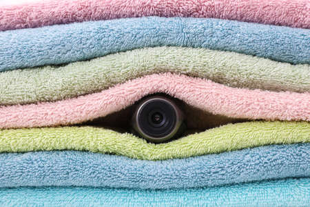Camera hidden between folded towels, closeup viewの写真素材