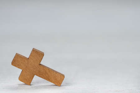 Wooden Christian cross on white table, space for textの写真素材