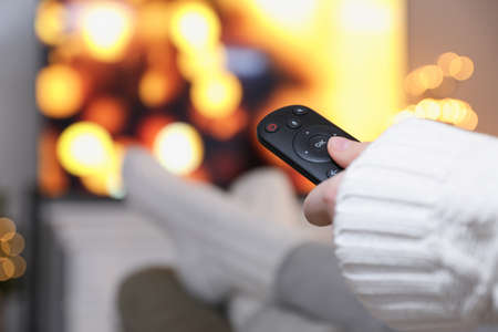 Woman with remote control in room decorated for Christmas, closeupの写真素材