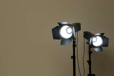 Modern spotlights against beige background, space for textの写真素材