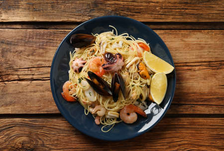 Delicious pasta with sea food on wooden table, top viewの写真素材