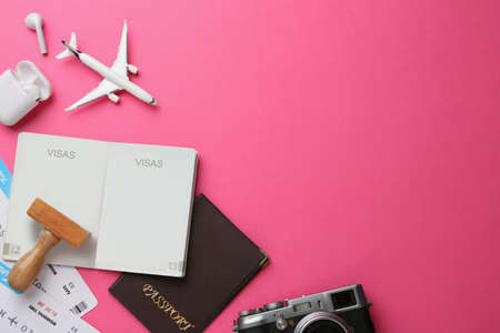 Flat lay composition with passports, stamp and flight tickets on pink background, space for textの写真素材